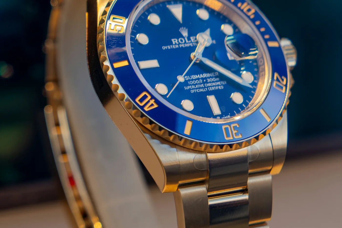 Luxury watch with a blue dial resting on a display stand